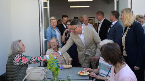Ministerpräsident Boris Rhein begrüßt Besucherinnen des neuen Dorfhauses in Schmitten